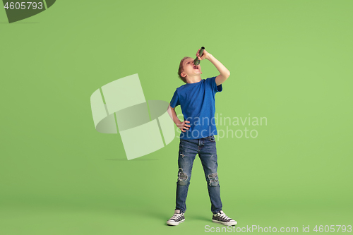 Image of Happy boy playing and having fun on green studio background, emotions