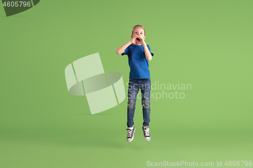 Image of Happy boy playing and having fun on green studio background, emotions