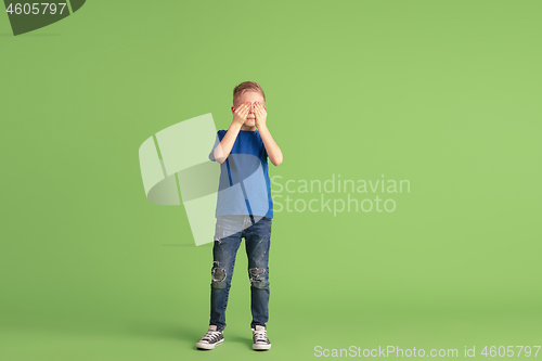 Image of Happy boy playing and having fun on green studio background, emotions