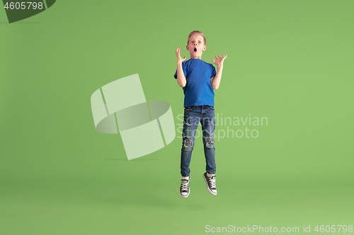 Image of Happy boy playing and having fun on green studio background, emotions