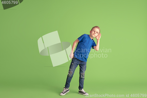 Image of Happy boy playing and having fun on green studio background, emotions