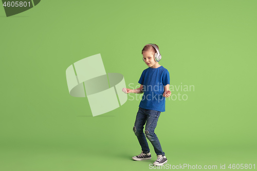 Image of Happy boy playing and having fun on green studio background, emotions