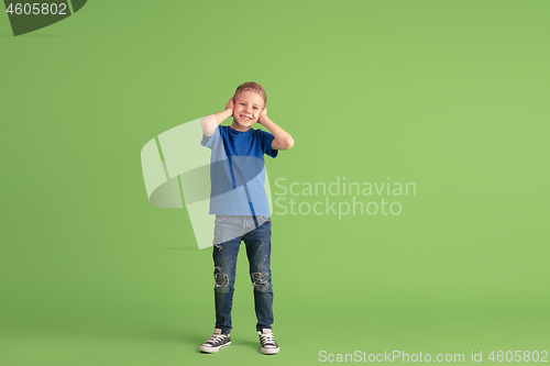 Image of Happy boy playing and having fun on green studio background, emotions