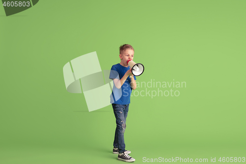 Image of Happy boy playing and having fun on green studio background, emotions