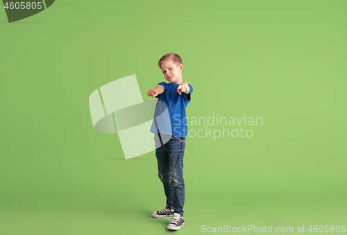 Image of Happy boy playing and having fun on green studio background, emotions