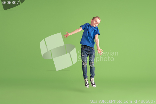 Image of Happy boy playing and having fun on green studio background, emotions