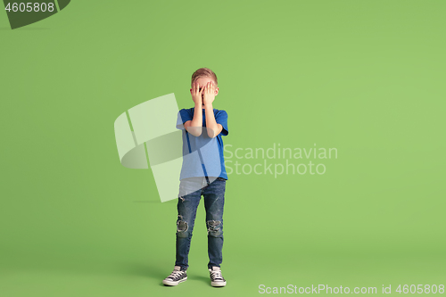 Image of Happy boy playing and having fun on green studio background, emotions