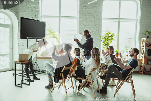 Image of Female african-american speaker giving presentation in hall at university workshop