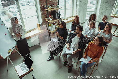 Image of Female muslim speaker giving presentation in hall at university workshop