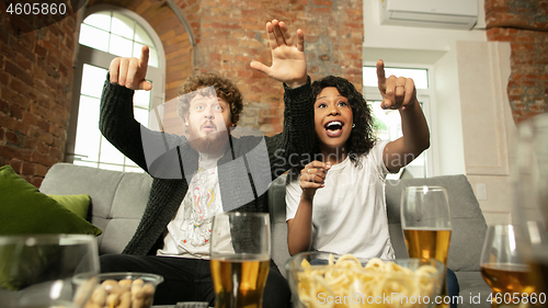 Image of Excited couple, friends watching sport match, championship at home