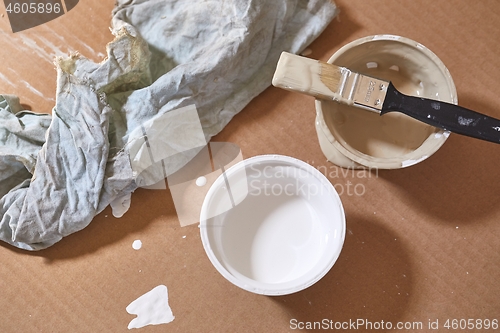 Image of Paint brush on a can of white wall paint