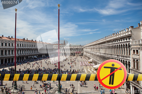 Image of Prohibition yellow sign with crossed out man on the background of San Marco square in Venice, Italy.