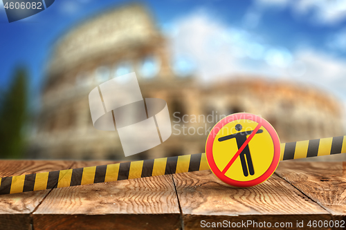 Image of Warning sign with crossed out man on the background of wooden table and blurred Colosseum in Rome, Italy.