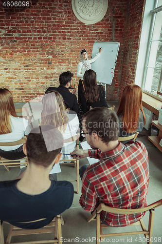 Image of Female muslim speaker giving presentation in hall at university workshop