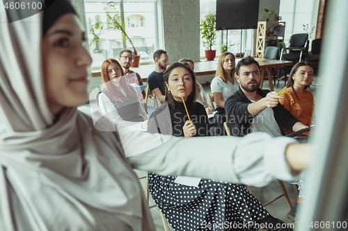 Image of Female muslim speaker giving presentation in hall at university workshop