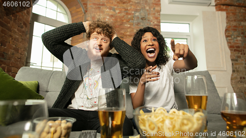 Image of Excited couple, friends watching sport match, championship at home