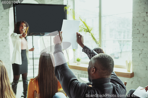 Image of Female african-american speaker giving presentation in hall at university workshop