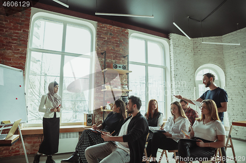 Image of Female muslim speaker giving presentation in hall at university workshop