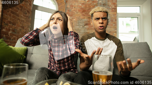 Image of Excited couple, friends watching sport match, championship at home