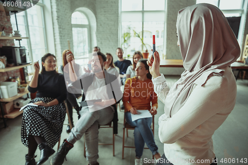 Image of Female muslim speaker giving presentation in hall at university workshop