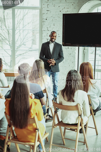 Image of Male african-american speaker giving presentation in hall at university workshop