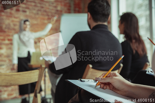 Image of Female muslim speaker giving presentation in hall at university workshop