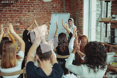 Image of Female muslim speaker giving presentation in hall at university workshop