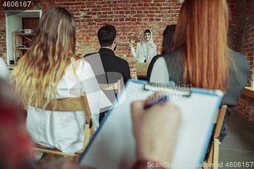 Image of Female muslim speaker giving presentation in hall at university workshop