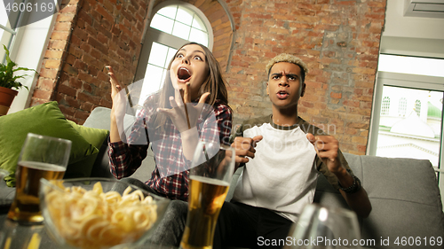 Image of Excited couple, friends watching sport match, championship at home