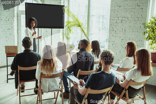 Image of Female african-american speaker giving presentation in hall at university workshop