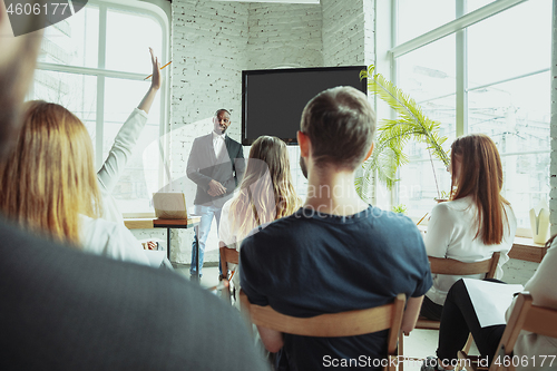 Image of Male african-american speaker giving presentation in hall at university workshop