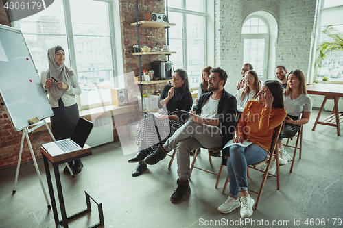 Image of Female muslim speaker giving presentation in hall at university workshop