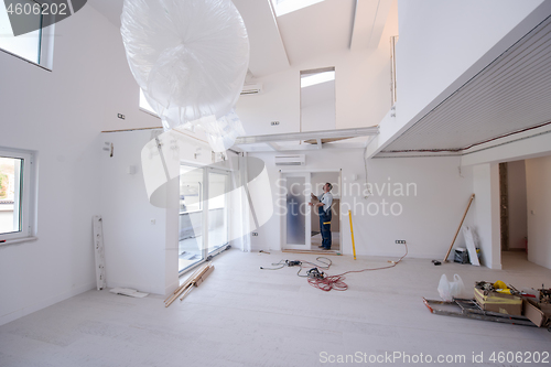 Image of carpenters installing glass door with a wooden frame