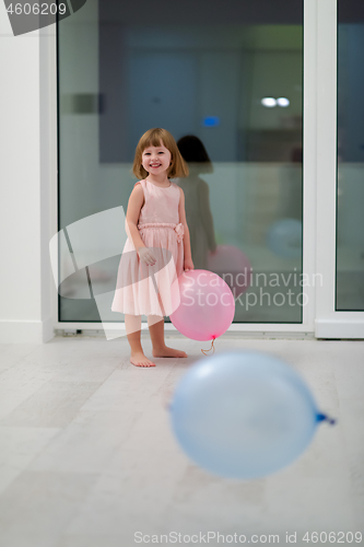 Image of cute little girl playing with balloons