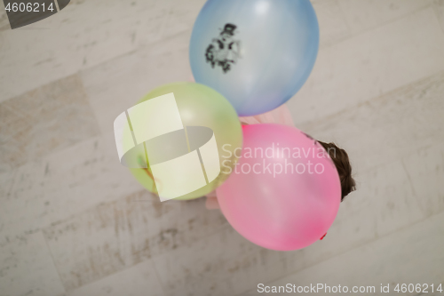 Image of cute little girl playing with balloons