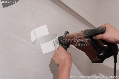 Image of construction worker drilling holes in the bathroom