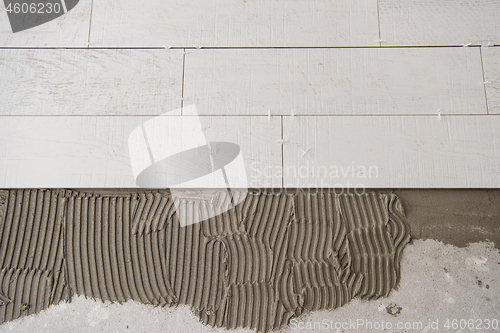 Image of Ceramic wood effect tiles and tools for tiler on the floor