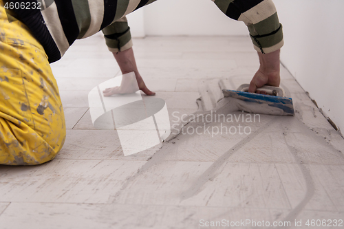 Image of Tilers filling the space between ceramic wood effect tiles