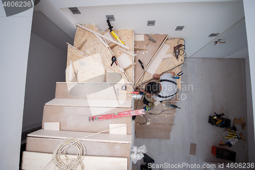 Image of carpenter installing wooden stairs