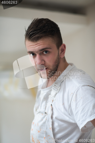 Image of portrait of construction worker with dirty uniform in apartment