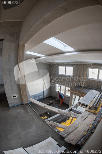 Image of worker performing and polishing sand and cement screed floor