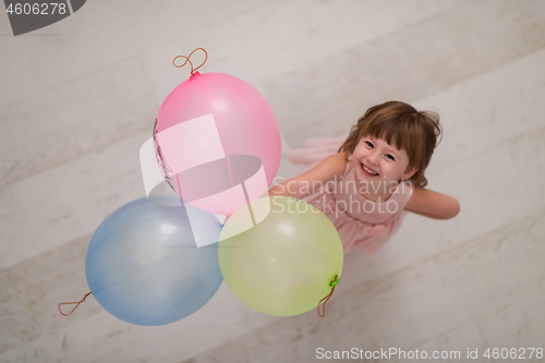 Image of cute little girl playing with balloons