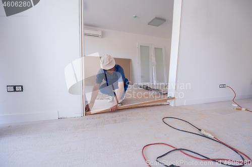 Image of carpenters installing glass door with a wooden frame