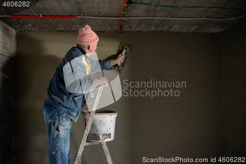 Image of Worker plastering the wall by concrete