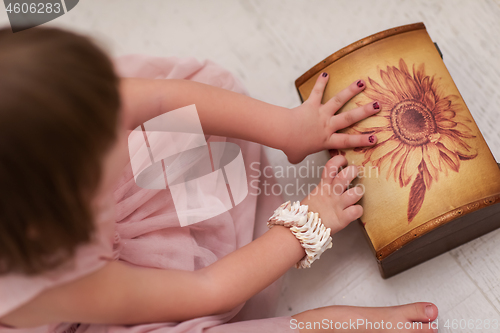 Image of little girl enjoying while playing with mother\'s jewelry