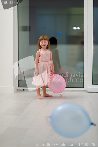 Image of cute little girl playing with balloons