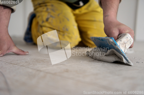 Image of Tilers filling the space between ceramic wood effect tiles