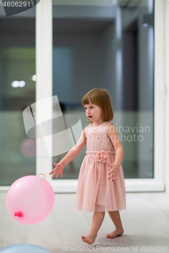 Image of cute little girl playing with balloons