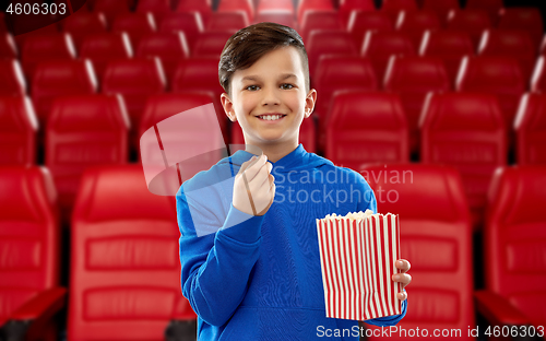 Image of happy smiling boy eating popcorn at movie theater