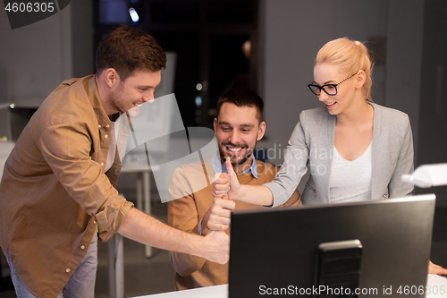 Image of business team making thumbs up gesture at office